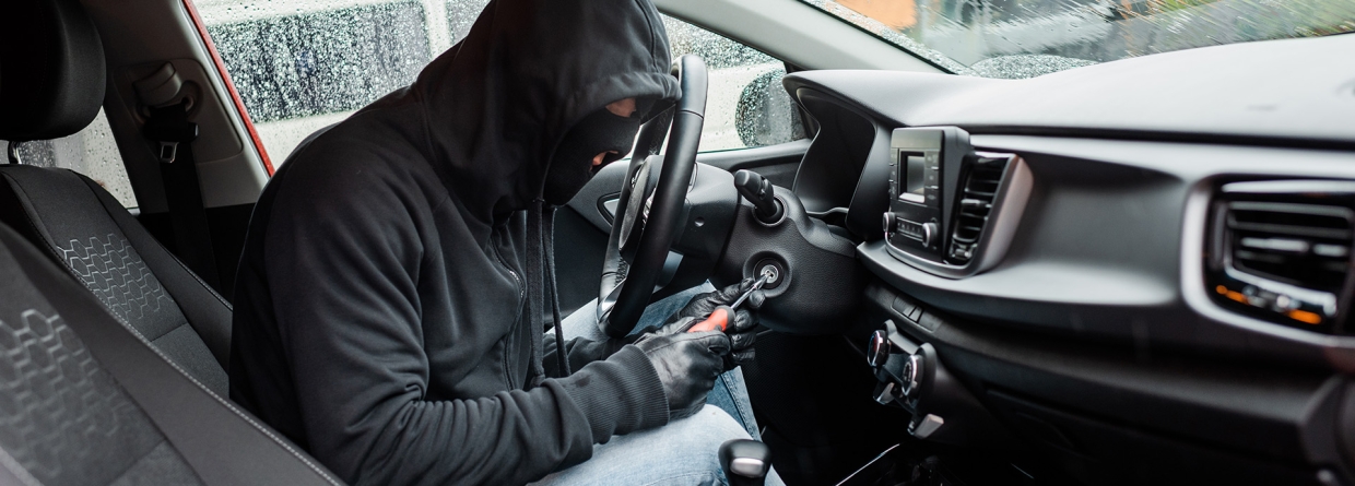 Autodiefstal; autodief zit in een auto met een bivakmuts en handschoenen aan en probeer de auto te starten met een schroevendraaier